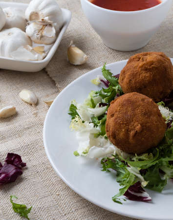 macaroni and cheese balls on white plate with saladの写真素材