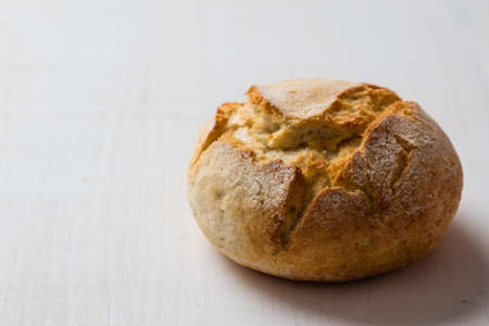 round fresh crusty bread bun on white tableの写真素材