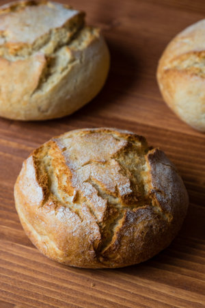 round fresh bread bun on brown wooden table