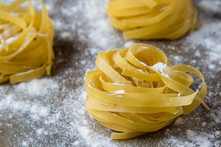 raw dry tagliatelle pasta on steel plateの写真素材