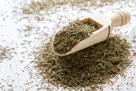 natural dried aromatic thyme on white table with scoop