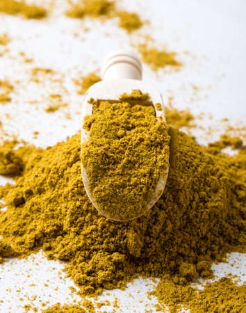 color healthy curry spice on white table with scoopの写真素材