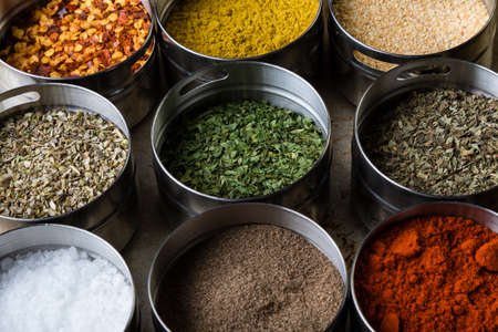 different colorful gourmet spices in steel bowlsの写真素材