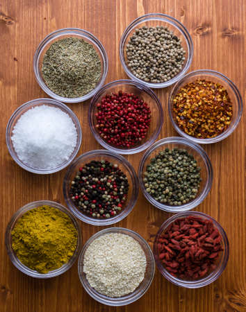 different colorful gourmet spices in small glass bowlsの写真素材