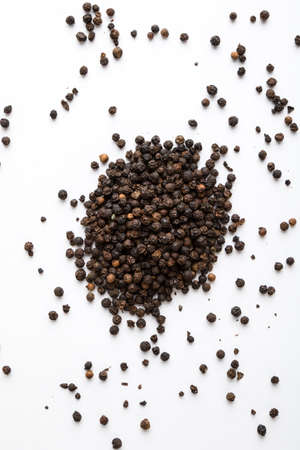 black color peppercorn seeds on white table