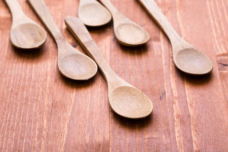 six brown wooden spoons on wooden tableの写真素材