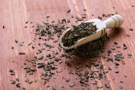 healthy dried oregano condiment on wooden table with scoopの写真素材