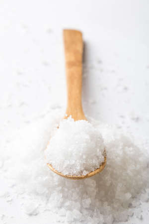 mineral sea salt on white table with spoonの写真素材