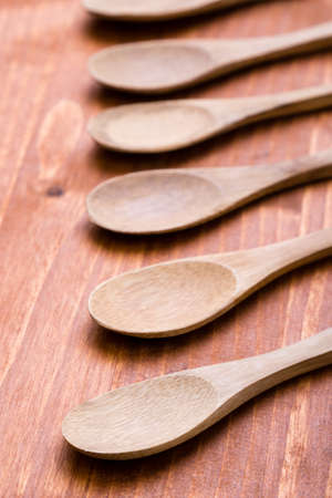 six brown wooden spoons on wooden tableの写真素材