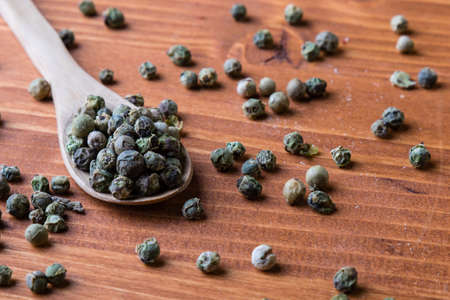 green color peppercorn seeds on wooden table with spoonの写真素材