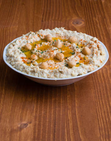 creamy delicious fresh home made hummus on wooden tableの写真素材