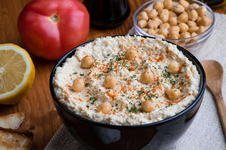 creamy delicious fresh home made hummus in black bowlの写真素材
