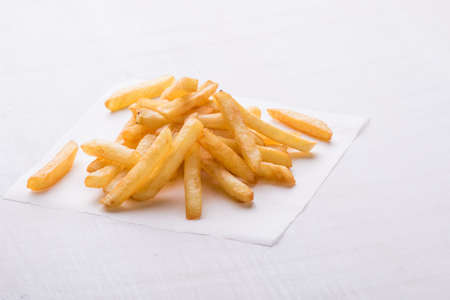 fresh yellow fries on a white table