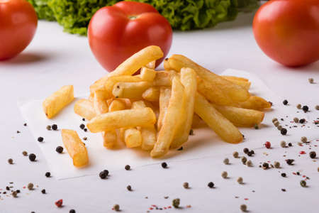 fresh yellow fries on white table with peppercorn seasoningの写真素材