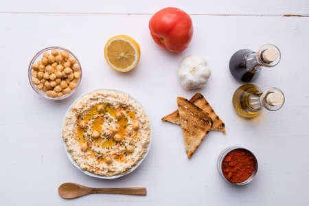 home made hummus in bowl on white tableの写真素材
