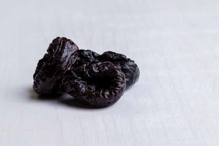 organic sweet dark prunes on white tableの写真素材