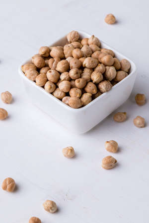 dry chickpeas on white table in a bowlの写真素材