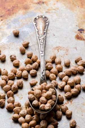 dry brown chickpeas on steel plate with spoonの写真素材