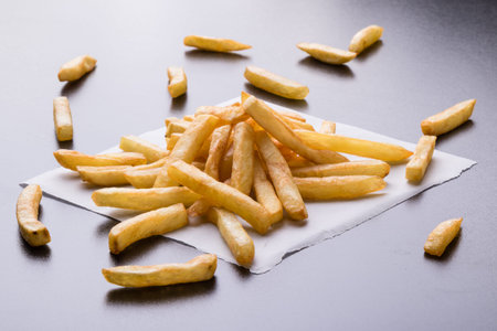 fresh yellow fries on a black table