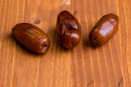 sweet dried dates fruit on wooden tableの写真素材