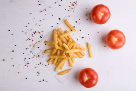 fresh yellow fries on white table with peppercorn seasoningの写真素材