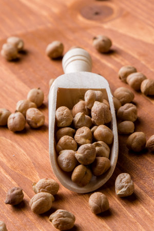 dry brown chickpeas with wooden scoop on tableの写真素材