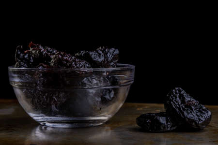 organic sweet dark prunes on steel plateの写真素材