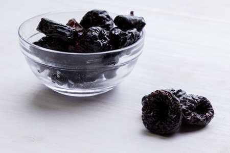 organic sweet dark prunes on white tableの写真素材