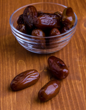 sweet dried dates fruit on wooden tableの写真素材