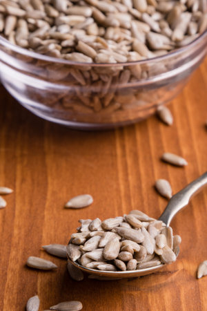 hulled sunflower seeds on wooden table and spoonの写真素材