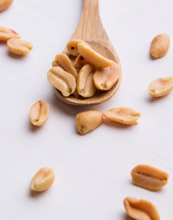 healthy natural brown peanuts on a wooden spoon