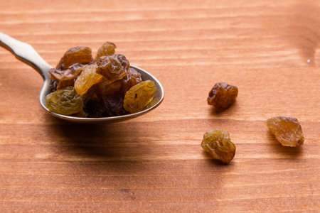 brown healthy sweet raisins on steel spoonの写真素材