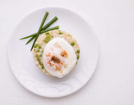 fresh vegetarian pea risotto with poached eggの写真素材