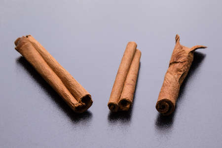 brown healthy cinnamon sticks spice on black tableの写真素材