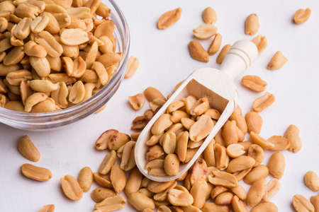 healthy natural brown peanuts on wooden scoop