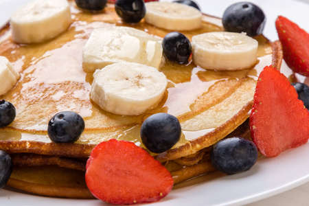 pancakes with blueberry, banana, strawberry and syrupの写真素材