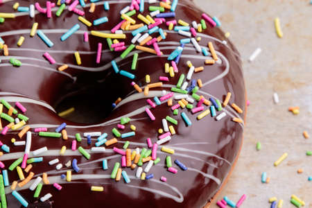 chocolate donut with sprinkles on steel plateの写真素材