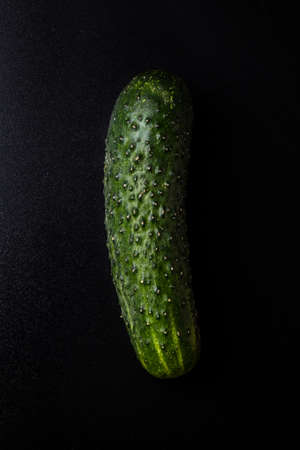 raw organic green cucumber on black tableの写真素材