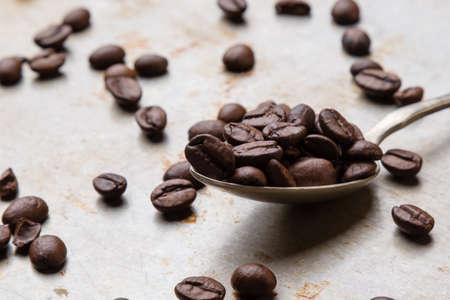 roasted coffee beans on steel plate with spoonの写真素材