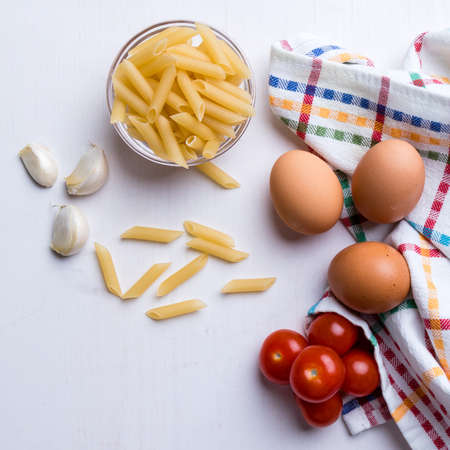 raw uncooked penne pasta on kitchen tableの写真素材