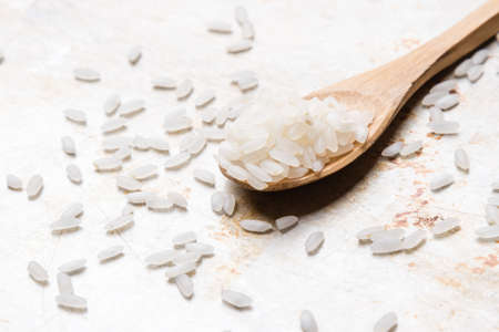 rice on wooden spoon on steel plateの写真素材