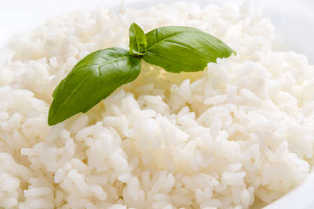cooked rice with basil on white plateの写真素材