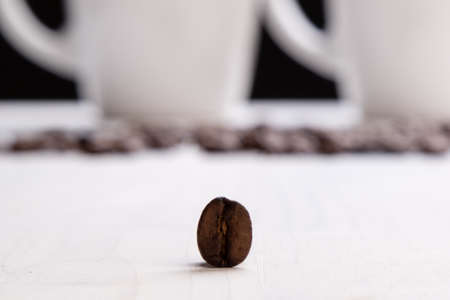 one brown roasted coffee bean on white tableの写真素材