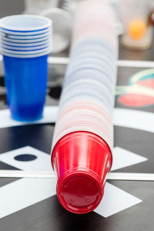pile of disposabel red and blue plastic cups on table