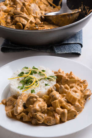 beef stroganoff with rice on white plateの写真素材