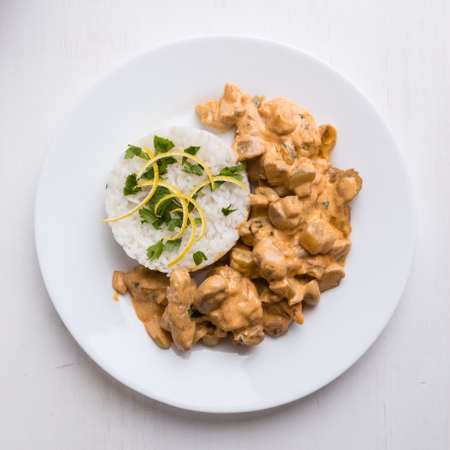 beef stroganoff with rice on white plateの写真素材