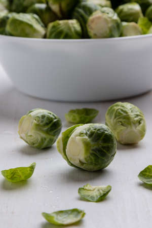 fresh brussels sprouts in white bowl on tableの写真素材