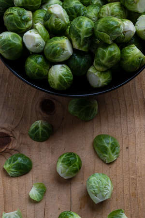 fresh brussels sprouts in black bowl on tableの写真素材