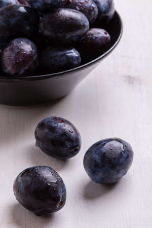 fresh organic tasty plums on white table