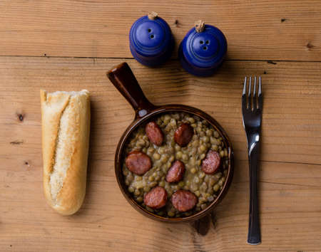 green lentil stew with sausage in brown bowlの写真素材